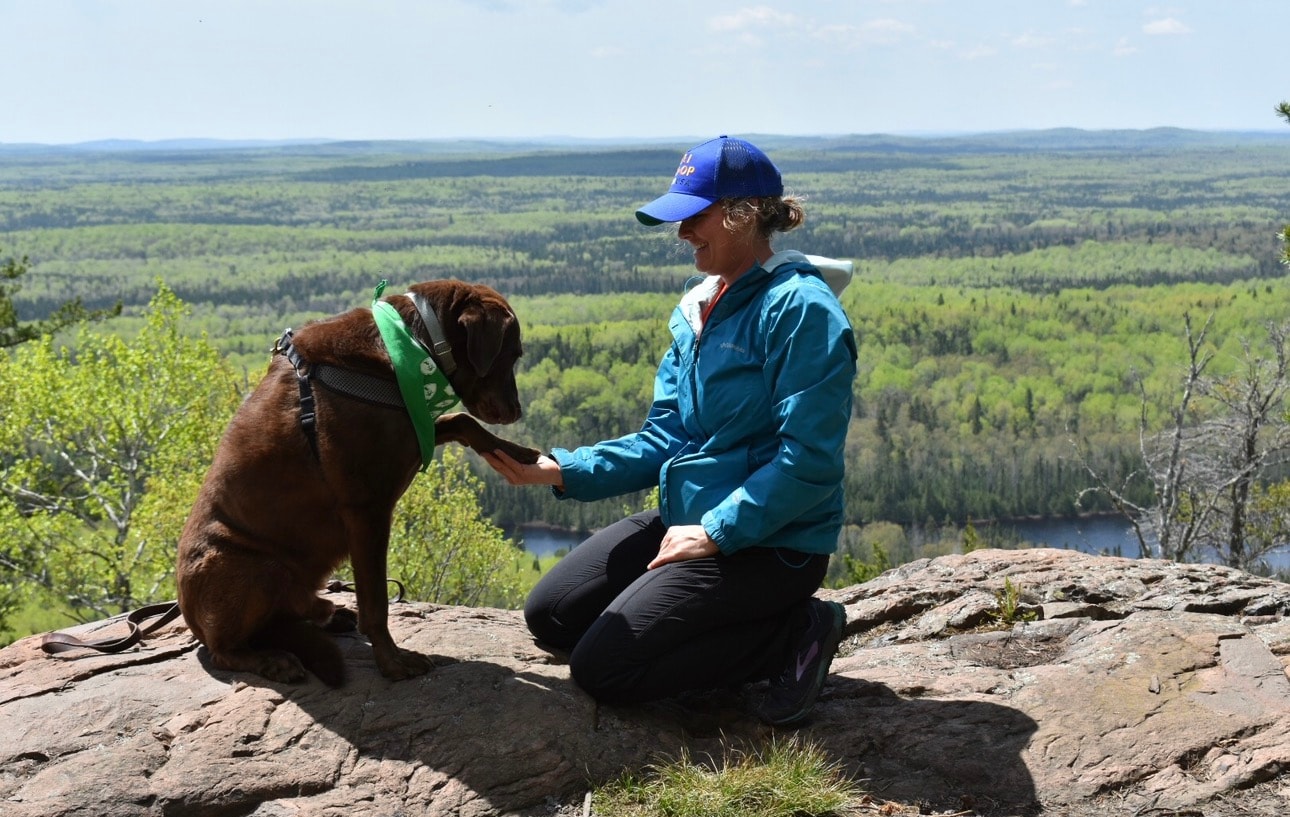 Natalie Runge with her dog on a scenic overlook